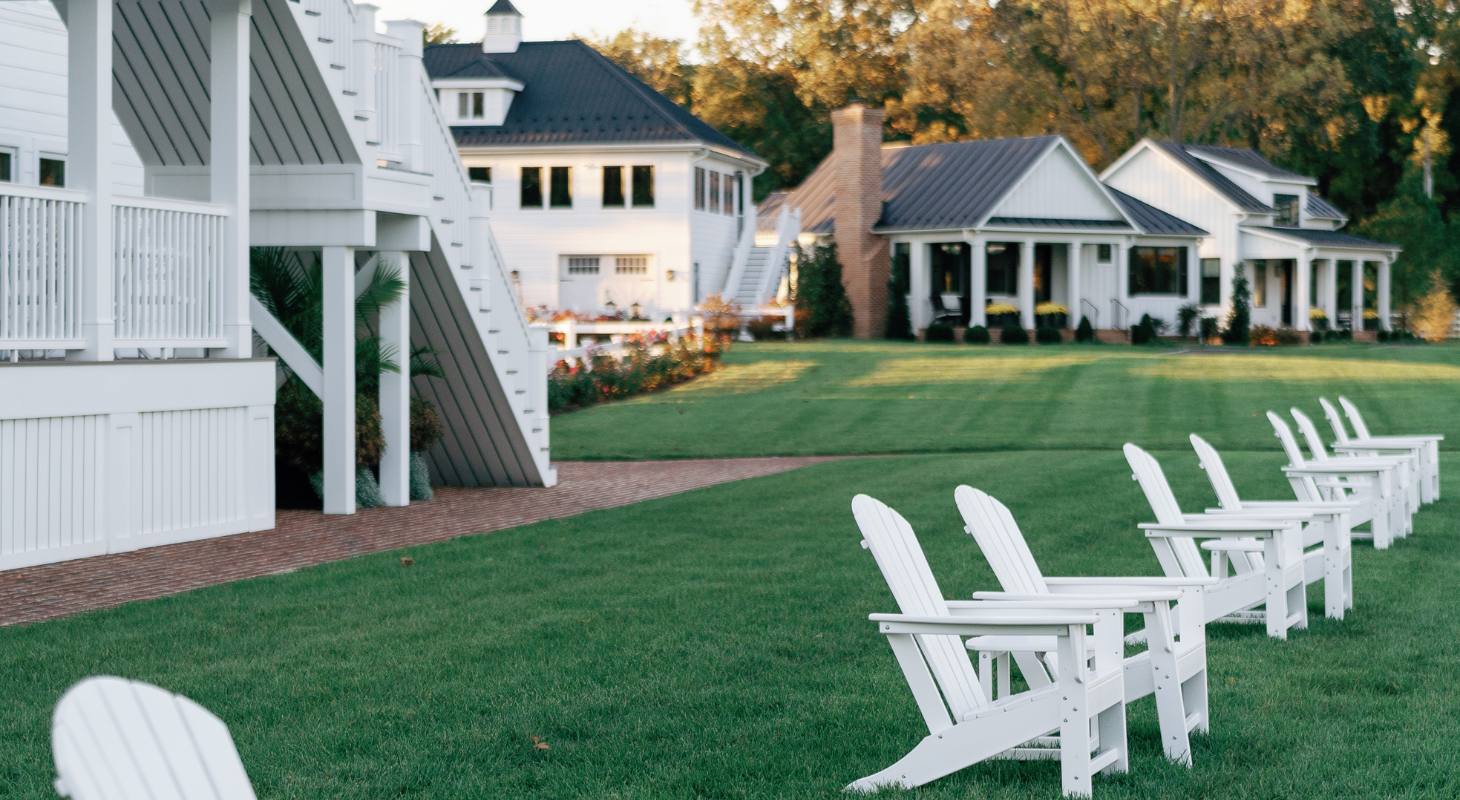 White chairs on the lawn at The Oaks Waterfront Hotel